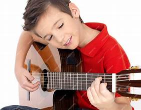 child with a smile holding
a guitar